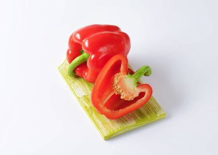 one and half red bell pepper on wooden cutting boardの写真素材