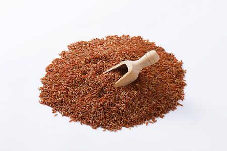 Heap of Camargue red rice and wooden scoopの写真素材