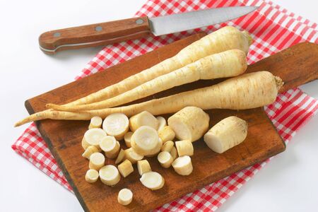 parsley roots on wooden cutting boardの写真素材