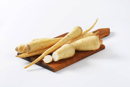 parsley roots on wooden cutting boardの写真素材