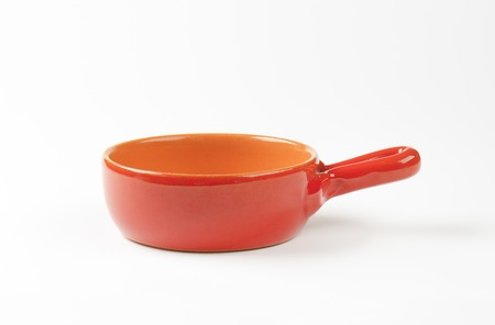 empty orange skillet on white backgroundの写真素材