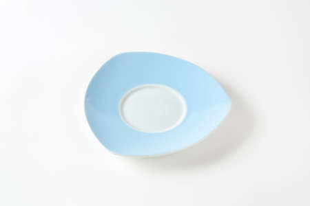 empty blue and white saucer on white background