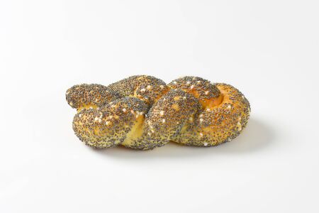 Braided bread roll topped with poppy seeds and saltの写真素材