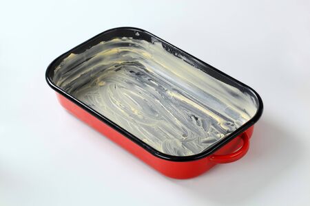 red baking pan greased with butterの写真素材