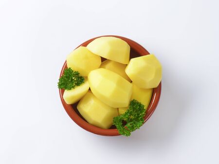 Raw peeled potatoes in ceramic dishの写真素材
