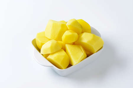 Raw peeled potatoes in ceramic dishの写真素材