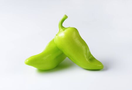 Two green peppers on white backgroundの写真素材