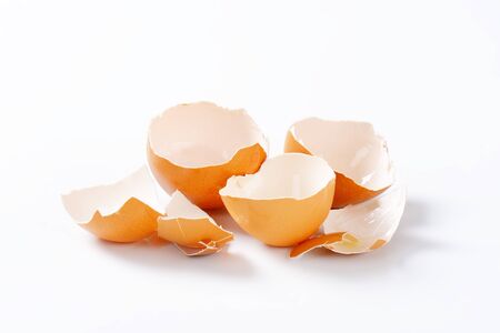 Empty brown egg shells on white background