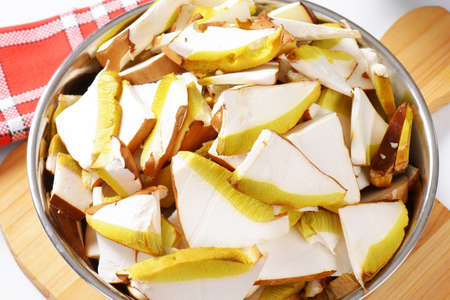 Sliced fresh mushrooms in metal bowl