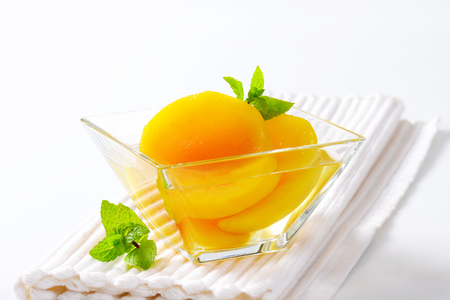 Bowl of peach halves in light syrupの写真素材