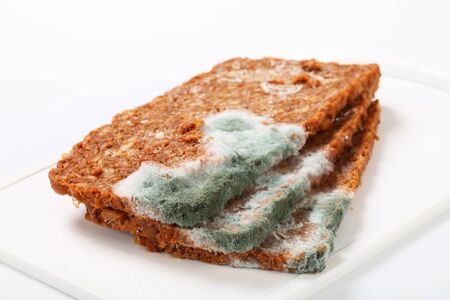 Slices of brown bread covered with moldの写真素材