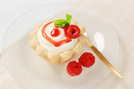 Mini tart with rich white cream and fresh red raspberriesの写真素材
