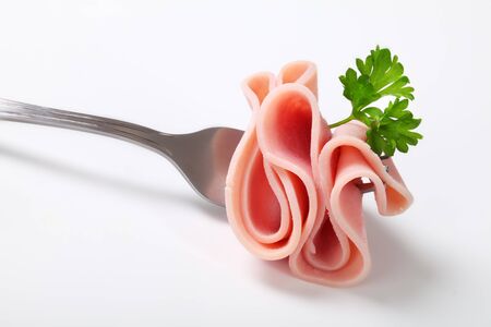 thin slice of ham on a forkの写真素材