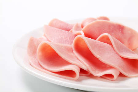 Thin slices of ham on white plateの写真素材