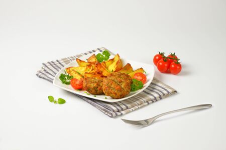 dish of vegetable and cheese patties with potato wedges