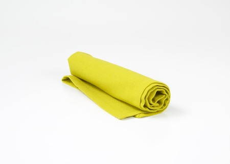 Rolled green cloth napkin on white backgroundの写真素材