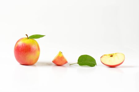 two apple quarters next to a whole appleの写真素材