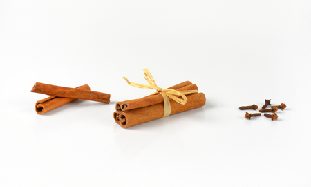 cinnamon sticks and dried cloves on white backgroundの写真素材