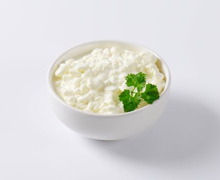 bowl of cottage cheese with fresh parsleyの写真素材