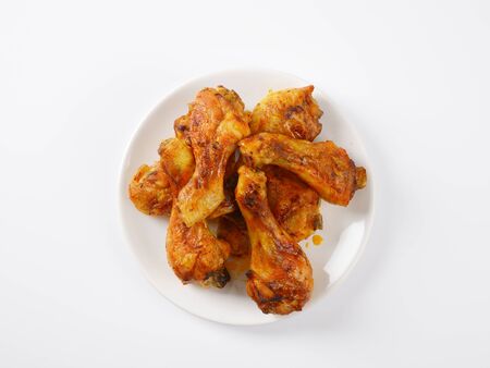 freshly roasted chicken legs on white plateの写真素材