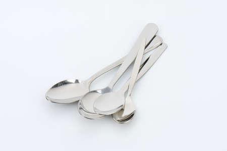 empty spoons on off-white backgroundの写真素材