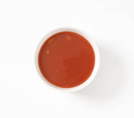 tomato soup in white porcelain bowlの写真素材