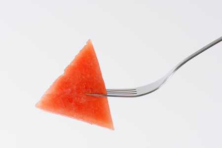 piece of fresh watermelon on silver forkの写真素材