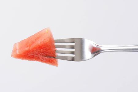 piece of fresh watermelon on silver forkの写真素材