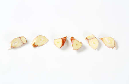 halved cloves of fresh garlic in a rowの写真素材