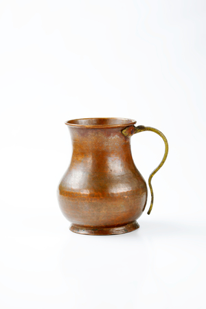 old hammered copper pitcher with brass handleの写真素材