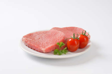 raw boneless pork loin chops on plateの写真素材