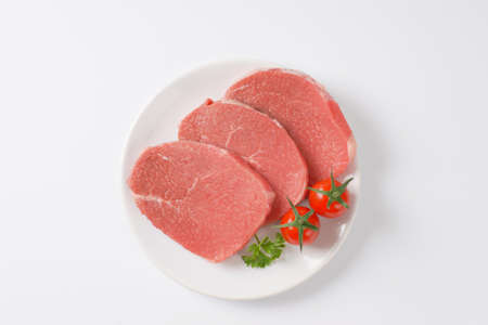 raw boneless pork loin chops on plate
