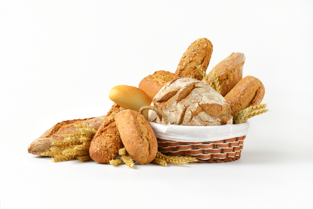 Various types of bread in a basket and next to itの写真素材