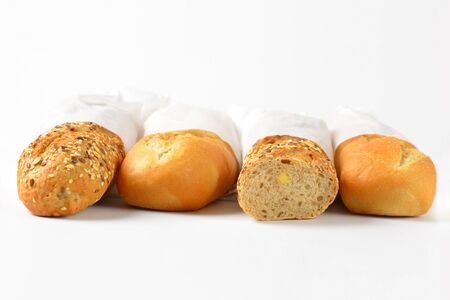 white and whole grain baguettes in paper bagsの写真素材