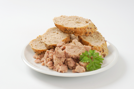pieces of canned tuna served with sliced seeded bread rollの写真素材