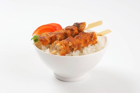bowl of rice and grilled chicken skewersの写真素材