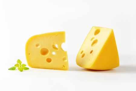 two wedges of Swiss cheese on white backgroundの写真素材