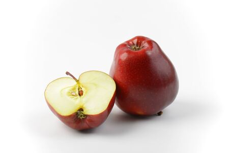 One and a half red apples on off-white backgroundの写真素材