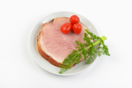 stack of ham slices, cherry tomatoes and dill on white plateの写真素材