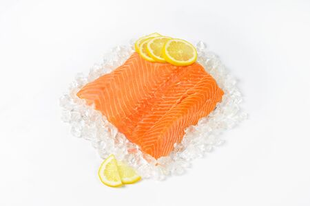 raw salmon fillet with slices of lemon on iceの写真素材