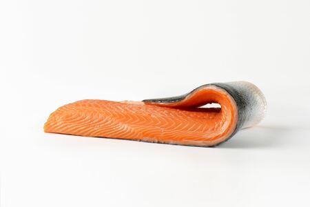 raw salmon fillet with skin on white backgroundの写真素材