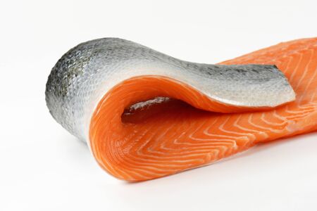 raw salmon fillet with skin on white backgroundの写真素材