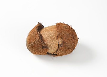 fresh coconut with broken husk on white background