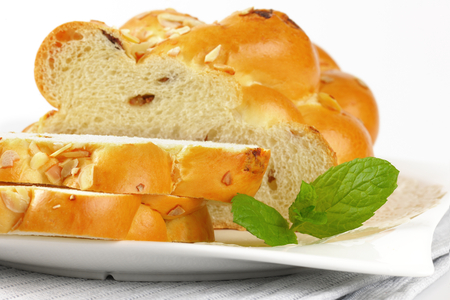 detail of sliced loaf of sweet braided bread with almonds and raisins