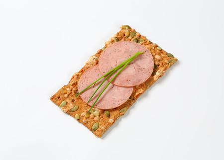 pumpkin seed cracker with thin slices of soft sausageの写真素材