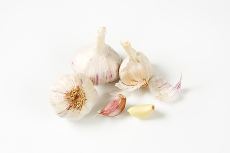 Fresh garlic bulbs and cloves on white backgroundの写真素材