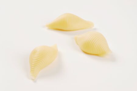 three pieces of pasta shells on white background - close upの写真素材