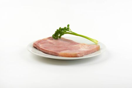 plate of fresh pork ham with parsley on white backgroundの写真素材