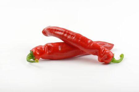 two red peppers on white background