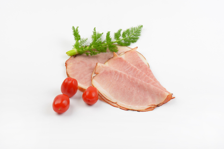 ham slices with fresh dill and cherry tomatoes on white backgroundの写真素材